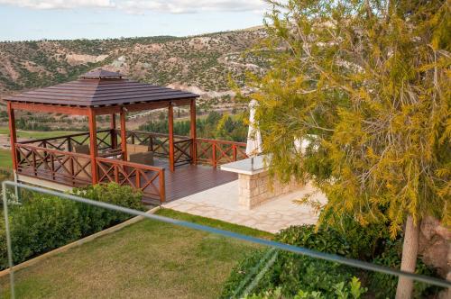 a wooden gazebo with a bench on a deck at Villa HERMIONA in Kouklia