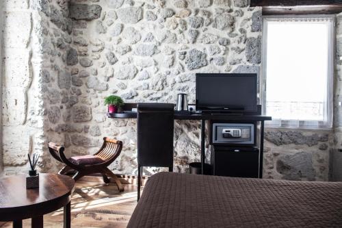 Una televisión o centro de entretenimiento en Hôtel Henri IV