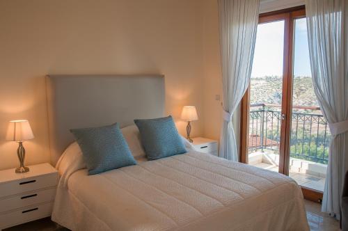 a bedroom with a bed and a large window at Villa HERMIONA in Kouklia