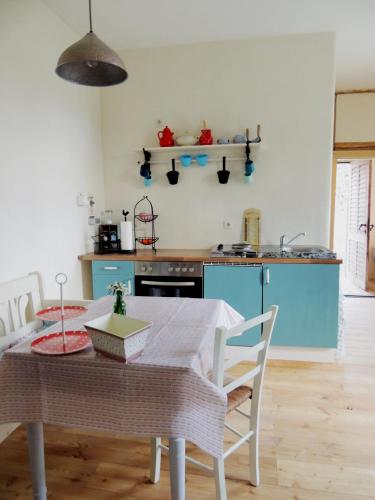 a kitchen with a table with chairs and a blue kitchen at Pfarrhof Stuer in Stuer