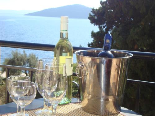 a bucket with a bottle of wine and glasses on a table at Mikros Gialos Apartments in Mikros Gialos
