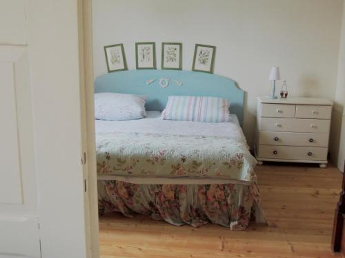 a bedroom with a bed with a blue headboard at Pfarrhof Stuer in Stuer
