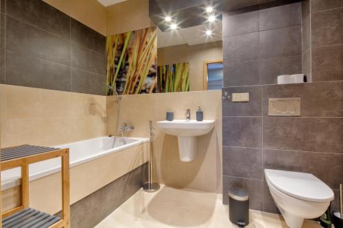 een badkamer met een wastafel, een toilet en een bad bij Apartament Bystra Woda 29 komfortowy centrum in Zakopane