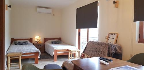 a living room with two beds and a chair at Apartments Aerodrom in Podgorica