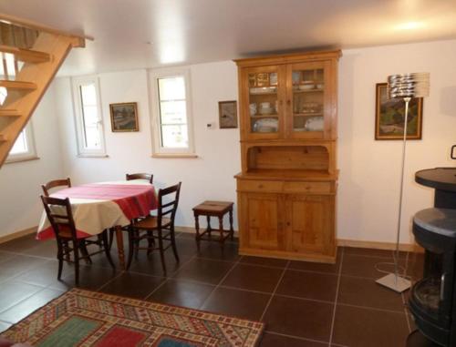 une cuisine et une salle à manger avec une table et des chaises dans l'établissement La Maison de Georges - Les Coquelicots, à Scharrachbergheim-Irmstett