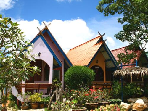 a small house with a pointed roof at Pongphen Guesthouse - SHA Plus Certified in Kanchanaburi