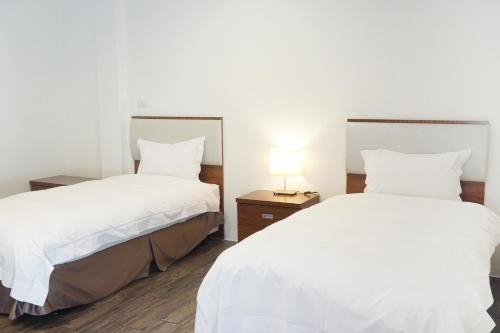 Postel nebo postele na pokoji v ubytování NCNU Campus Inn暨大行旅