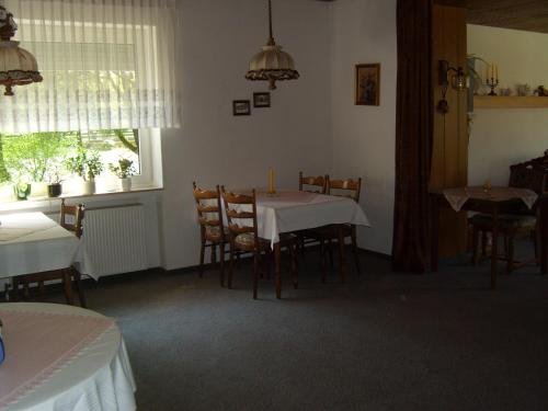 una sala da pranzo con tavolo, sedie e finestra di Ferienhof Temme a Bad Rothenfelde