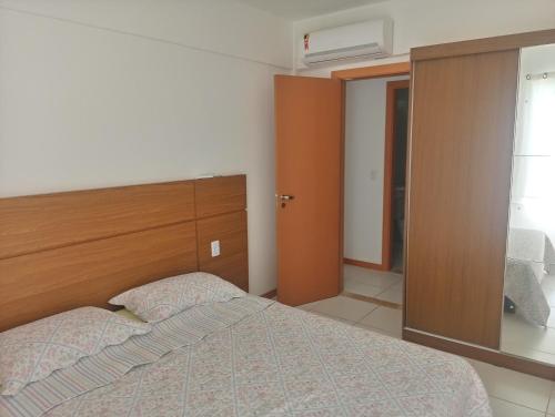 um quarto com uma cama e uma cabeceira em madeira em Apto. Vila dos Lírios - Reserva Imbassai em Imbassaí