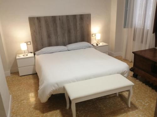 una camera da letto con un grande letto bianco e due comodini di Casa Rute a Rute