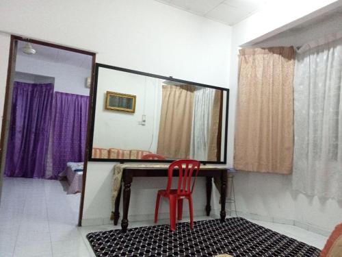 una silla roja sentada frente a un espejo en Muslim Homestay Ustaz 2 en Taiping