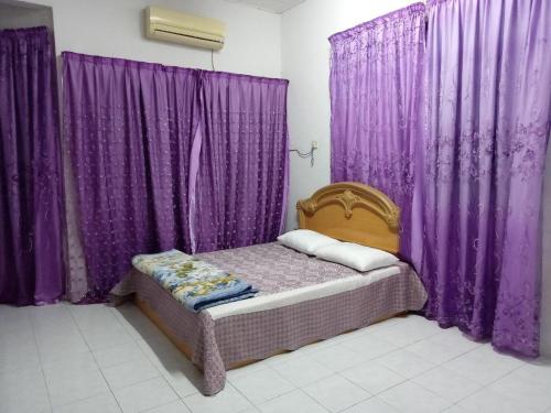 a bedroom with purple curtains and a bed with aitures at Muslim Homestay Ustaz 2 in Taiping