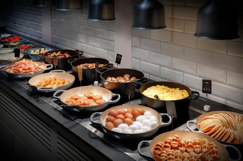 una cocina con muchas sartenes de comida en una estufa en Crowne Plaza Berlin City Centre Ku'damm by IHG, en Berlín