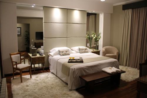 1 dormitorio con 1 cama grande, mesa y sillas en MG Design Hotel Boutique en Salta