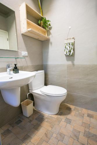 a bathroom with a toilet and a sink at Tree House Café & Homestay in Tongluo