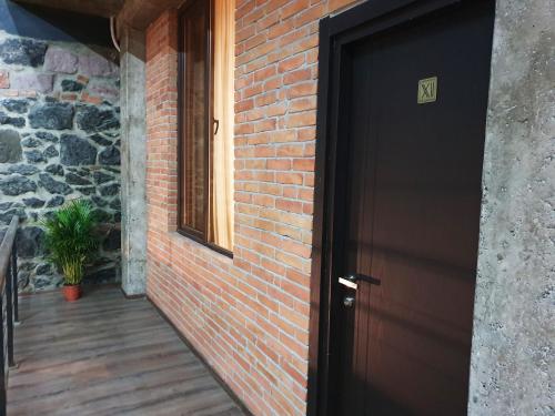 a black door leading to a brick wall at Taba Hall Boutique Hotel in Akhaltsikhe