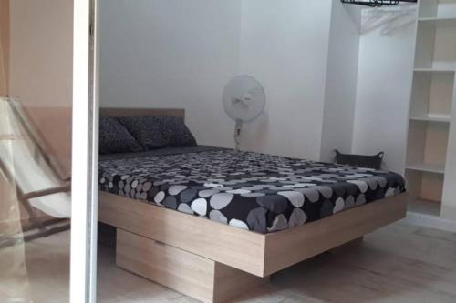 a bed in a room with a fan at Résidence Ti'Kéol - Appartements avec terrasse 2 à 4 personnes, piscine in Sainte-Anne