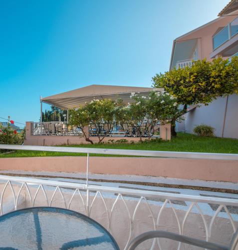 a glass table in front of a building at Odysseus Hotel in Paleokastritsa
