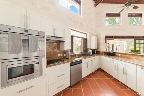 a large kitchen with white cabinets and stainless steel appliances at Mustard Seed in Saint Peter