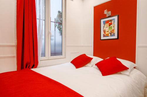 - un lit avec des oreillers rouges et blancs et une fenêtre dans l'établissement 25 - Fun Duplex in Montorgueil, à Paris