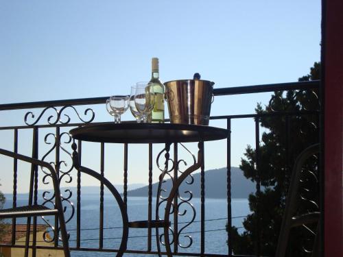 a table with wine glasses and a bucket on a balcony at Mikros Gialos Apartments in Mikros Gialos