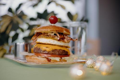 a sandwich with a cherry on top on a plate at A&M Hotel with free parking in Plovdiv