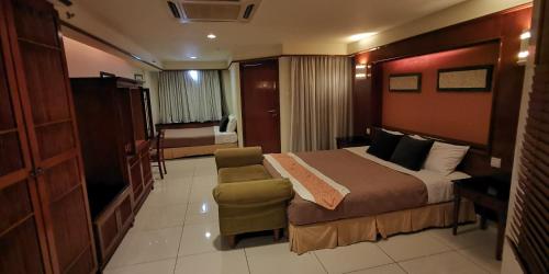 Habitación de hotel con cama y silla en Water Chalet or Premium Tower Seaview Port Dickson , Private Room en Port Dickson