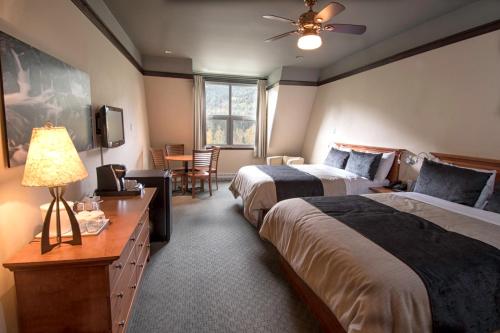 een hotelkamer met 2 bedden en een tafel bij Gîte du Mont-Albert - Sepaq in Sainte-Anne-des-Monts