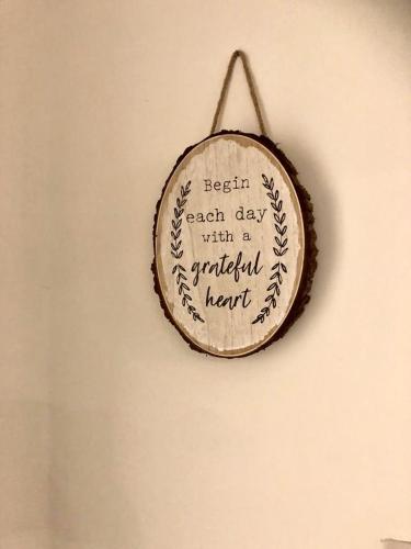 a wooden sign on a wall with the words begin each day with a grateful heart at BELMONT Apartments in Liverpool