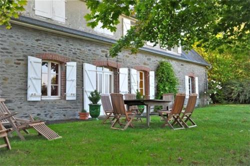a table and chairs in front of a brick house at Entre Mont St Michel et Merveille in Vains