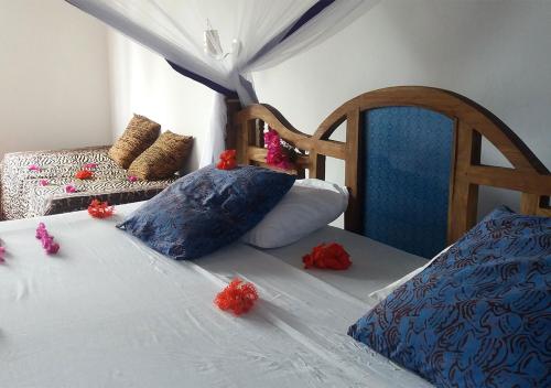 a bedroom with a bed with red flowers on it at Laguna Palace Zanzibar in Michamvi