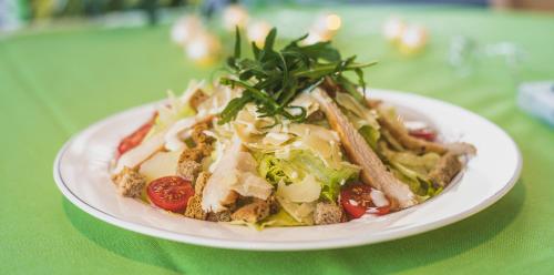 a white plate of food on a green table at A&M Hotel with free parking in Plovdiv