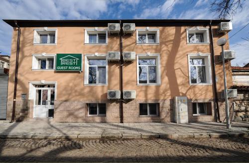 a brown building with a green sign on it at Best Rest Guest Rooms in Plovdiv