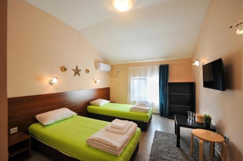 ein Hotelzimmer mit 2 Betten und einem Tisch in der Unterkunft Best Rest Guest Rooms in Plowdiw