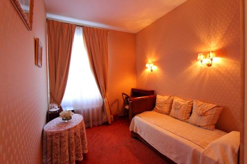 a bedroom with a bed and a table and a window at Hotel de la Bretonnerie in Paris
