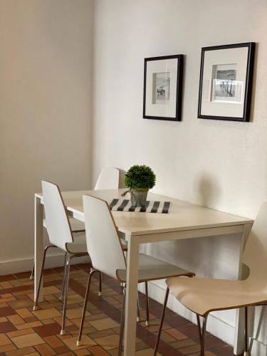 a dining room with a table and white chairs at Harding Boutique Apartments in Miami Beach
