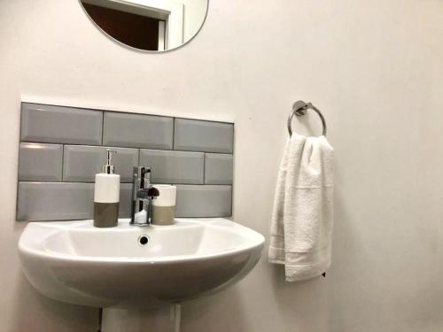 a bathroom with a white sink and a mirror at BELMONT Apartments in Liverpool