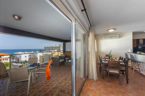a room with a balcony with a table and chairs at Seafront Protaras Apartments in Protaras
