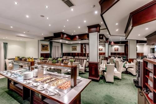 a restaurant with tables and chairs and a buffet at Hotel Bellevue - Half Board in Pamporovo