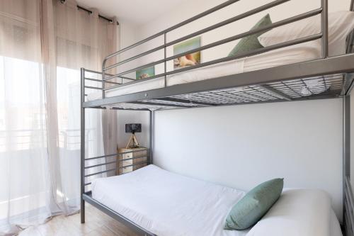 um quarto com 2 beliches e uma janela em matarolux17 em Mataró
