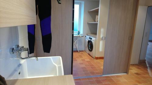 une salle de bain avec un lavabo et une machine à laver dans l'établissement Maison familiale-Surf House, plage de Sainte Barbe, à Plouharnel