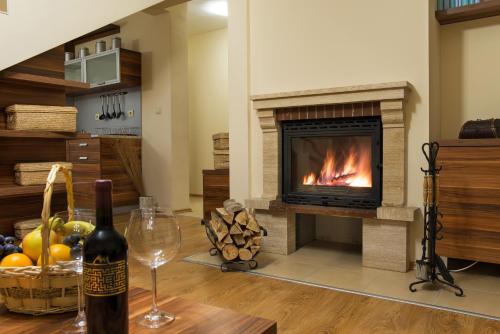 a bottle of wine and a wine glass in a living room with a fireplace at Mountain Lake Hotel in Smolyan