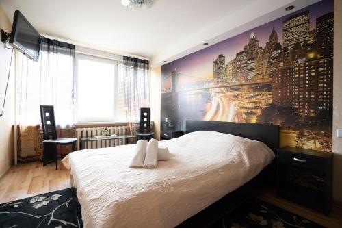 1 dormitorio con 1 cama con un mural de la ciudad en la pared en Asimarė, en Vilna