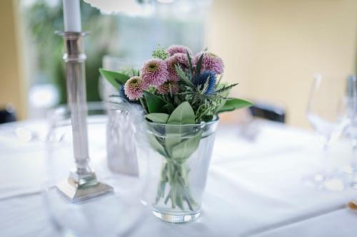 a vase filled with flowers sitting on a table at Gasthaus & Pension Mohren in Pfullendorf