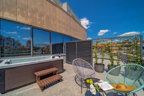a patio with chairs and a hot tub on a building at Priska Med Luxury Rooms in Split