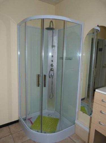 une douche avec une cabine en verre dans une salle de bain dans l'établissement Entre Terre et Mer, à Bias