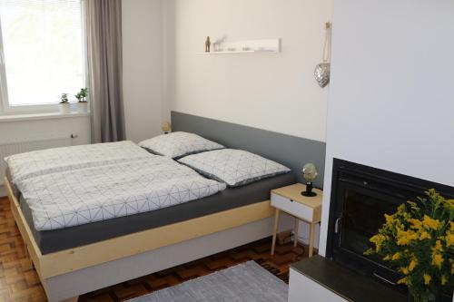 ein kleines Schlafzimmer mit einem Bett und einem Kamin in der Unterkunft Apartmán U Zastávky in Ratíškovice