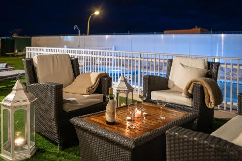 an outdoor patio with chairs and a table with candles at Villa Dalara Maspalomas, Private Pool and Jacuzzi in Maspalomas