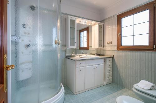 a bathroom with a shower and a toilet and a sink at Villa Dalara Maspalomas, Private Pool and Jacuzzi in Maspalomas