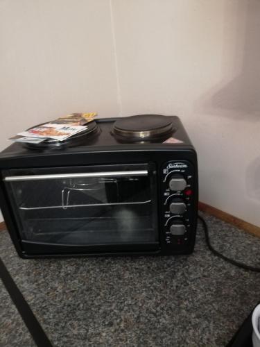 a black toaster oven sitting on top of a counter at KIHARA GUESTHOUSE in Bethlehem